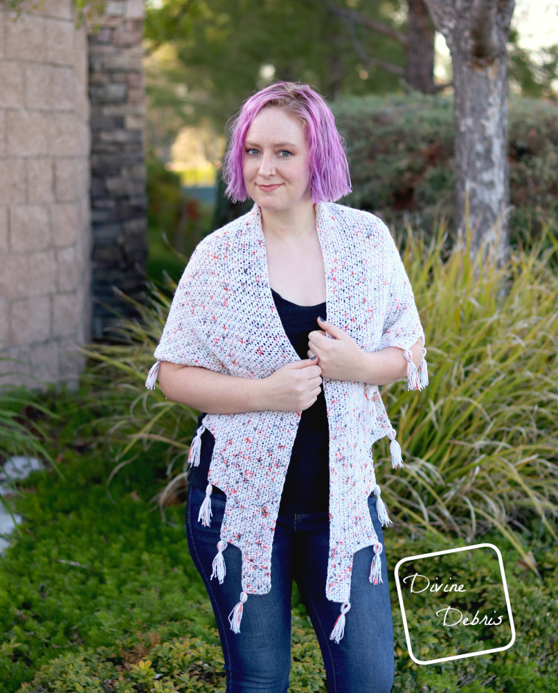 [image description]White woman with purple hair stands in front of trees and bushes with a white Lois Shawl draped around her shoulders.
