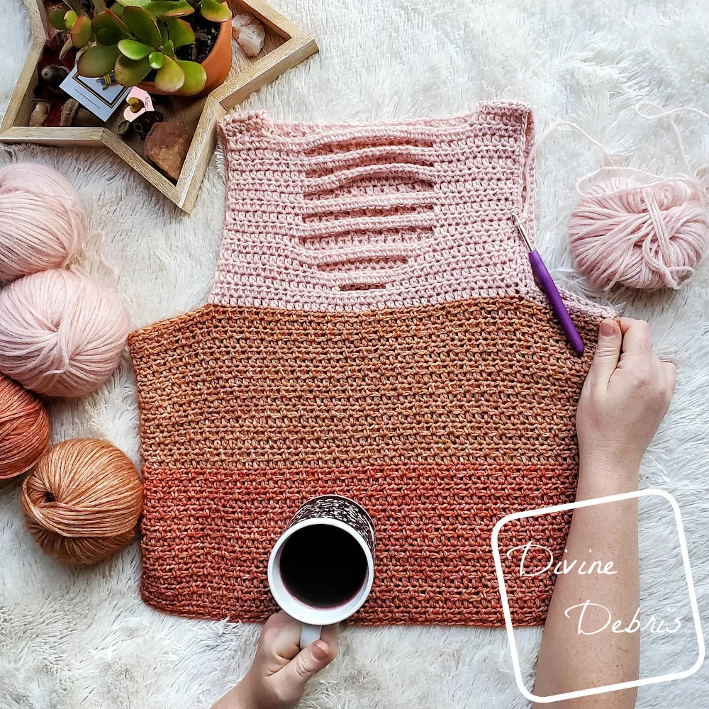 {image description] the Alix Tank top lays in the center of the frame, a white woman's hand crasps the right side and holds a cup of coffee over the bottom of the top. 