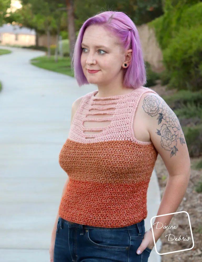 [image description] while wearing the Alix Tank Top, a white woman with purple hair stands looking to the left the camera with one hand in her back jean pockets. 