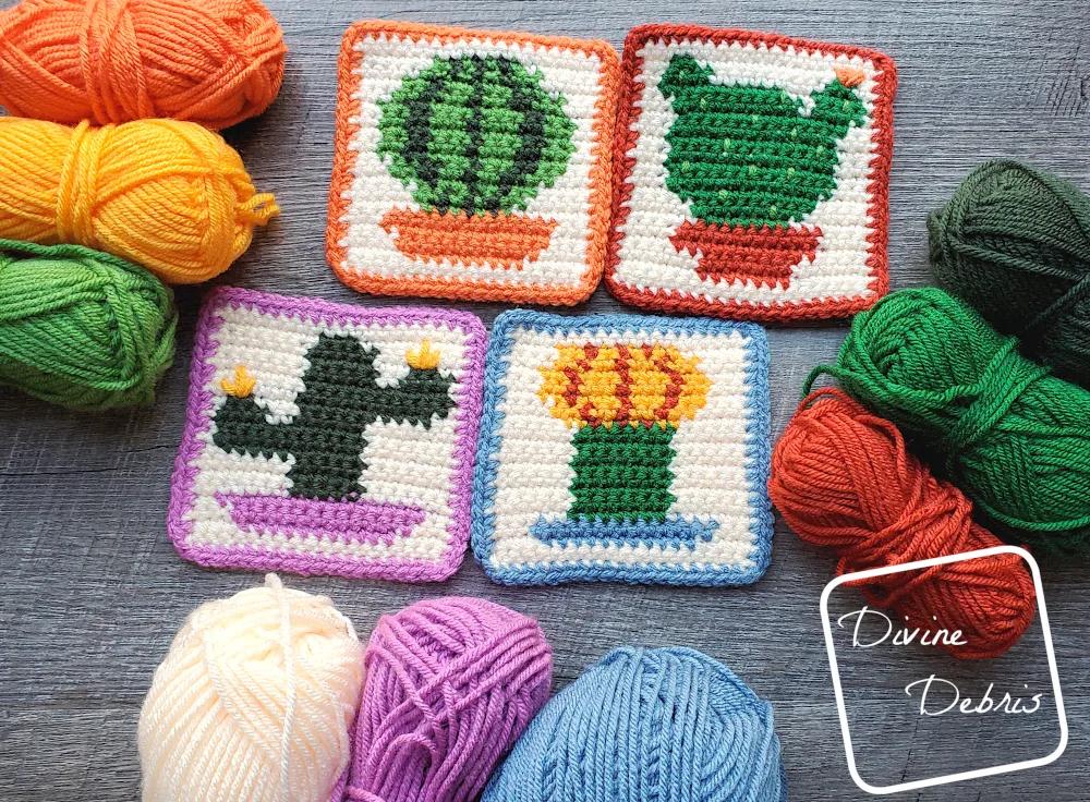 The four cactus coasters lay in the center of the photo, with stacks of 3 skeins of yarn around the sides and bottom of the photo .