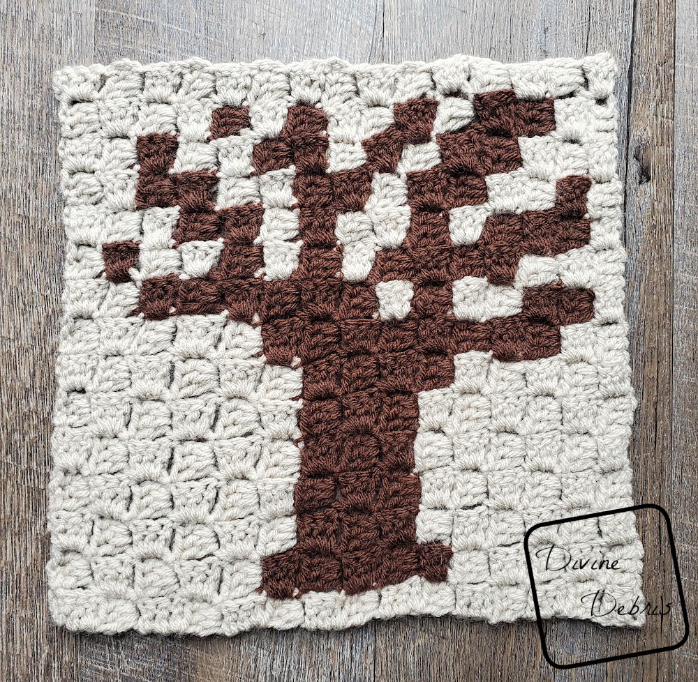 [Image description] The Spooky Tree Afghan Square lays in the center of the frame on a wood grain background.