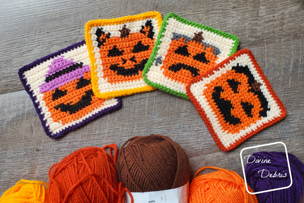 [Image description] The four Halloween Pumpkin Coasters crochet patterns lay flat on a wood-grain background with 5 skeins of yarn along the bottom of the photo.