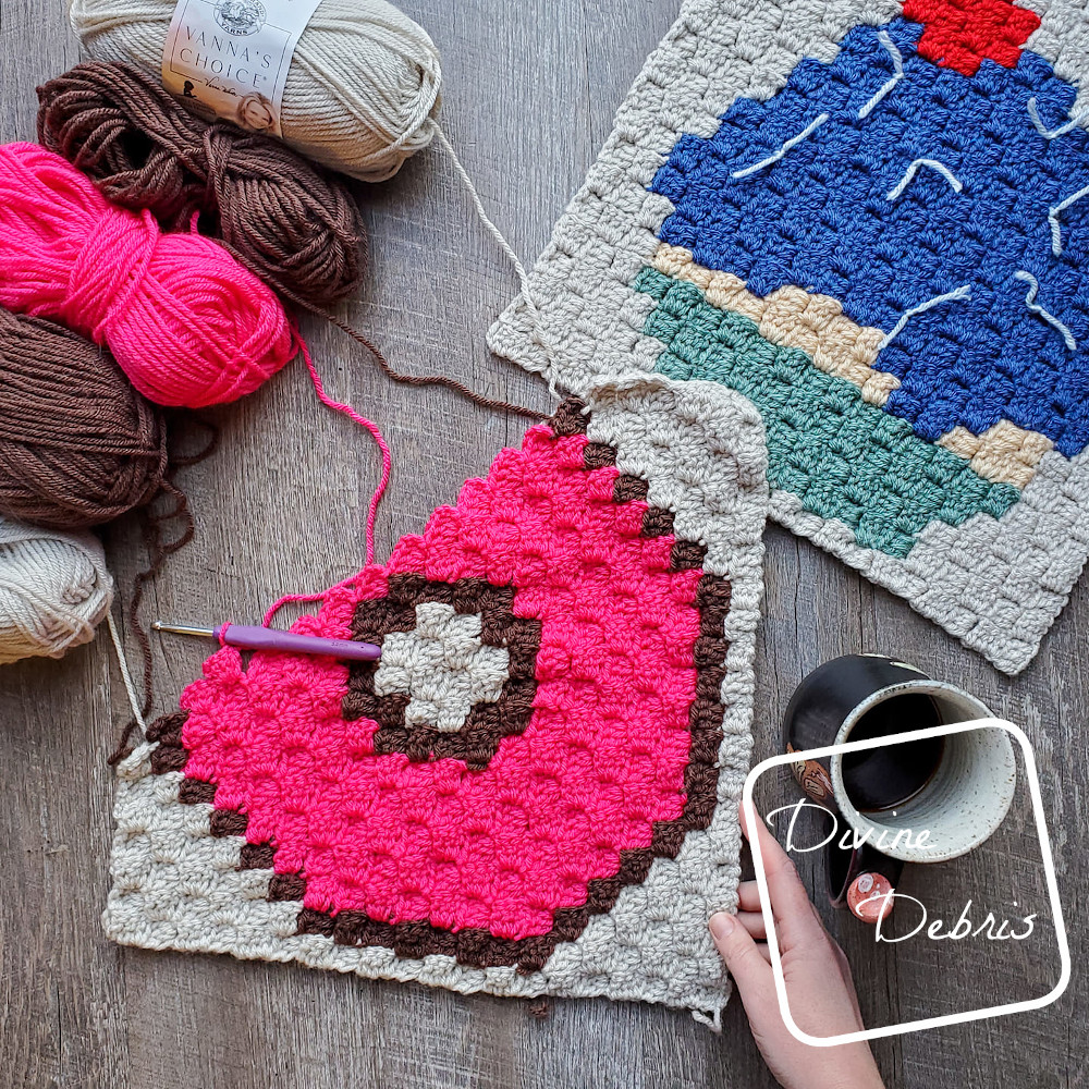 {Image description] the C2C Donut Afghan Square lays unfinished on a fake wood background, skeins of yarn are on the top left of the photo and the C2C Cupcake Afghan Square on the top right.