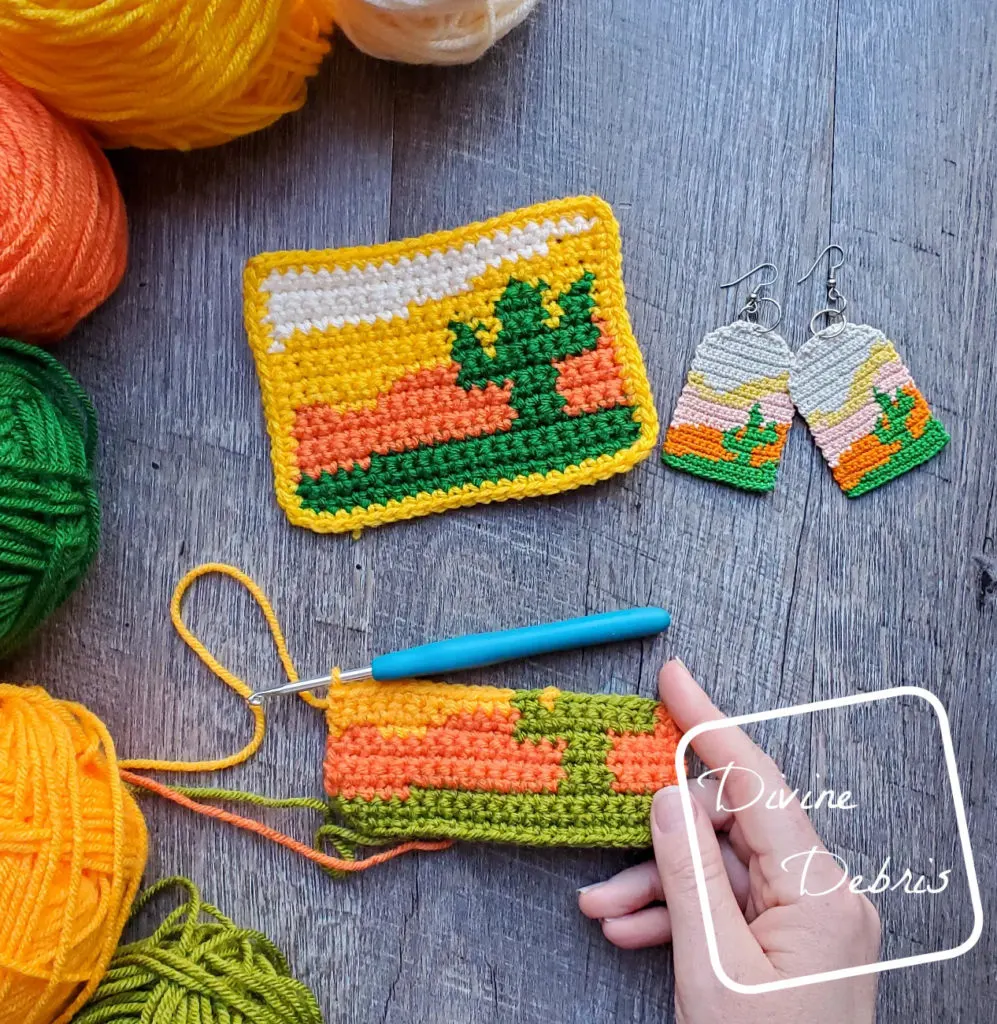 [Image description] top down view of a white woman's hand holding an unfinished Sedona Cactus Mug Rug with a finished one above.