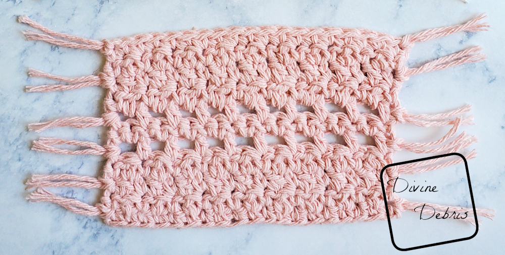 [Image description] a close up of the Kieran Mug Rug in pink on a white stone looking background. 