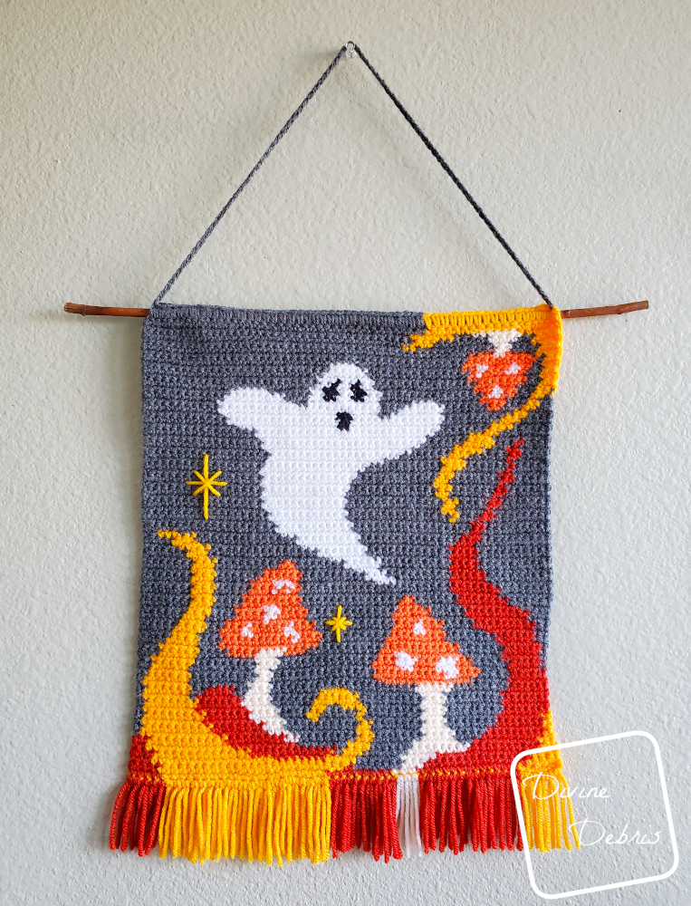 [Image description] The Ghost in the Mushrooms Wall Hanging on a cream colored wall
