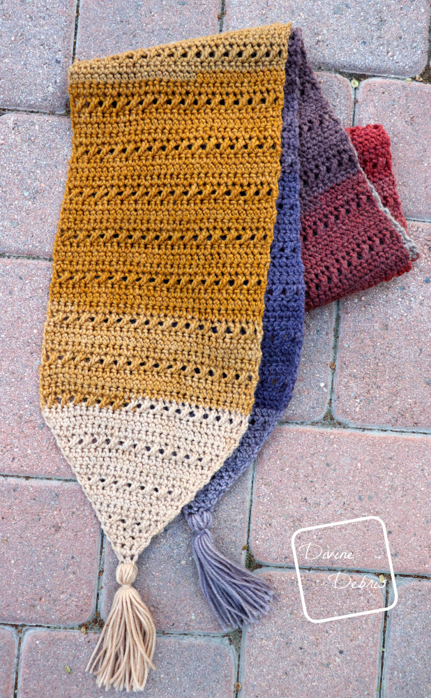 [Image description] Top down view of the Sophie Scarf laying flat on a red brick background
