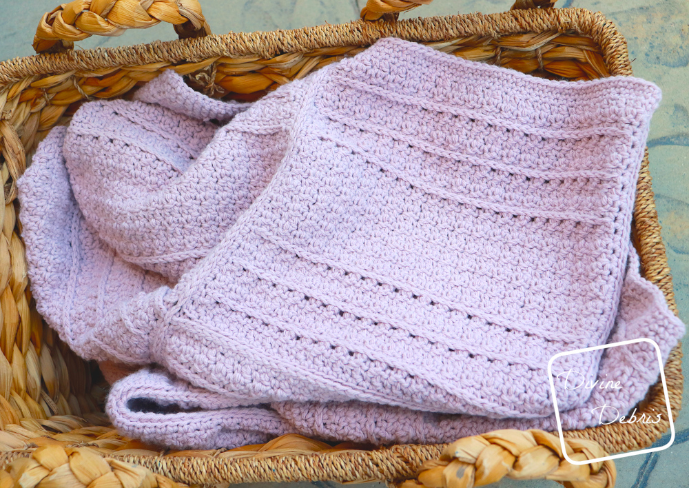 [Image description] the lavender Kieran Blanket lays folded in a basket
