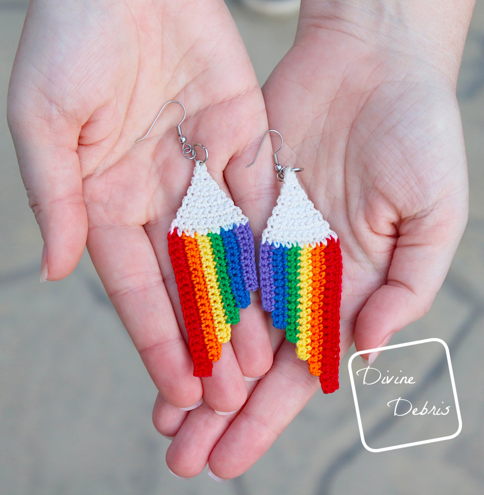 [image description] A top down view of the Cascade Rainbow Earring being held up to the camera in a white woman's hands.
