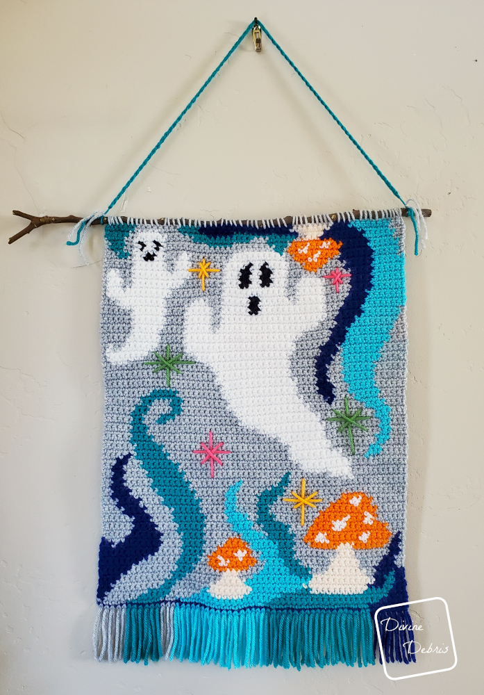 [Image description] the Ghosts of the Blue Lagoon Wall Hanging hangs on a off-white wall.
