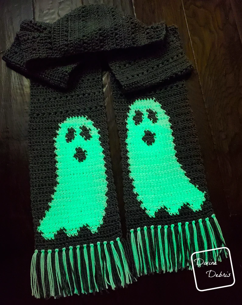 [Image description] A dark photo of the glowing Gloria Ghost Scarf crochet pattern, showing how the ghost look when they glow in the dark.