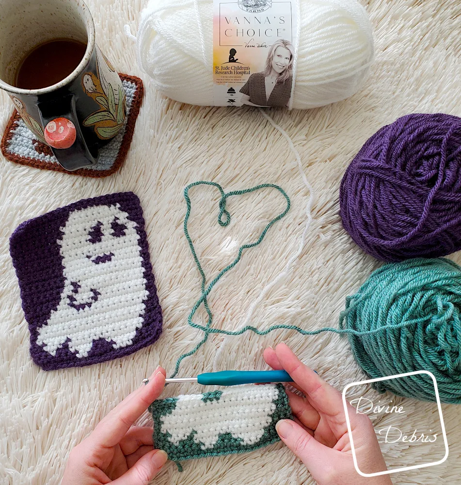 [Image description] Top down view of the a white woman's hands working on an unfinished Smiling Ghost Coaster Crochet Pattern