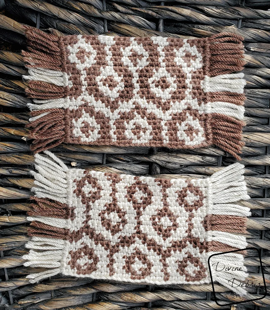 [Image description] Top down view of 2 Torrance Mug Rug crochet coasters on a woven wood background, stacked one above the other.
