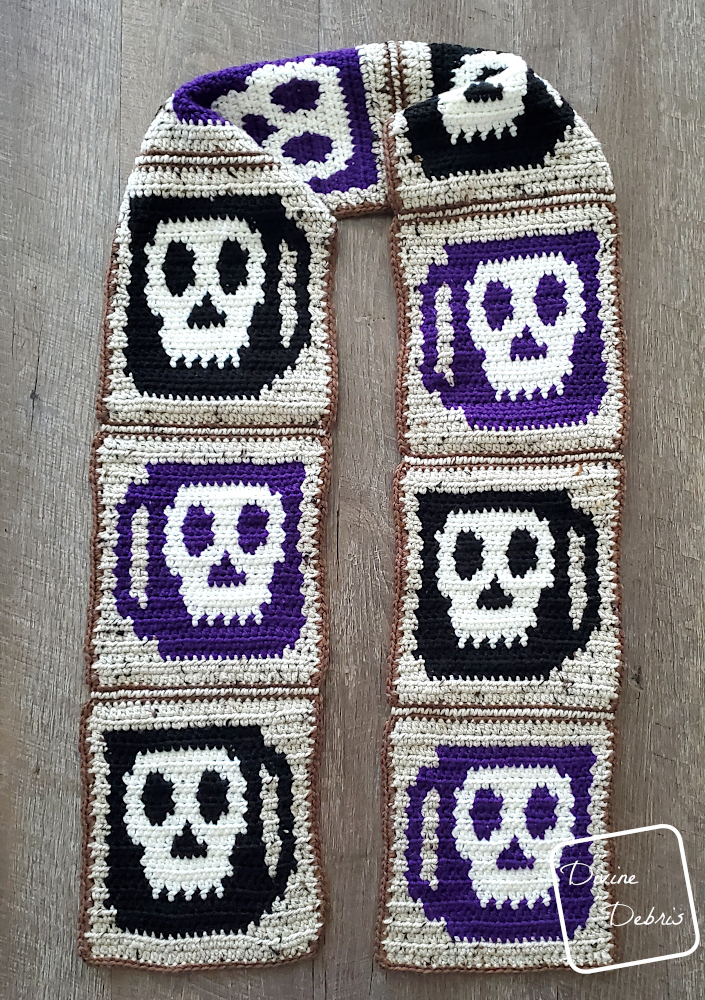 [Image description] A finished Wake the Dead Scarf lays on a fake wood grain background.