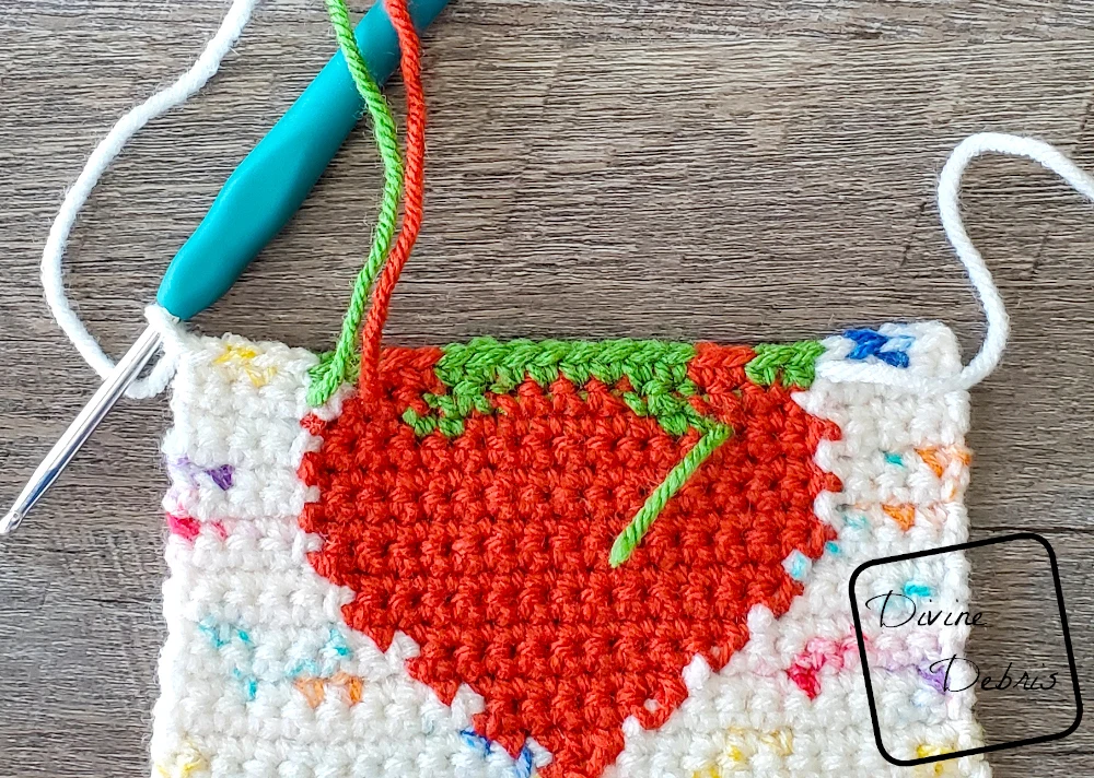 [image description] close up look of the wrong side of a Cute Strawberry Bag square on a fake wood background