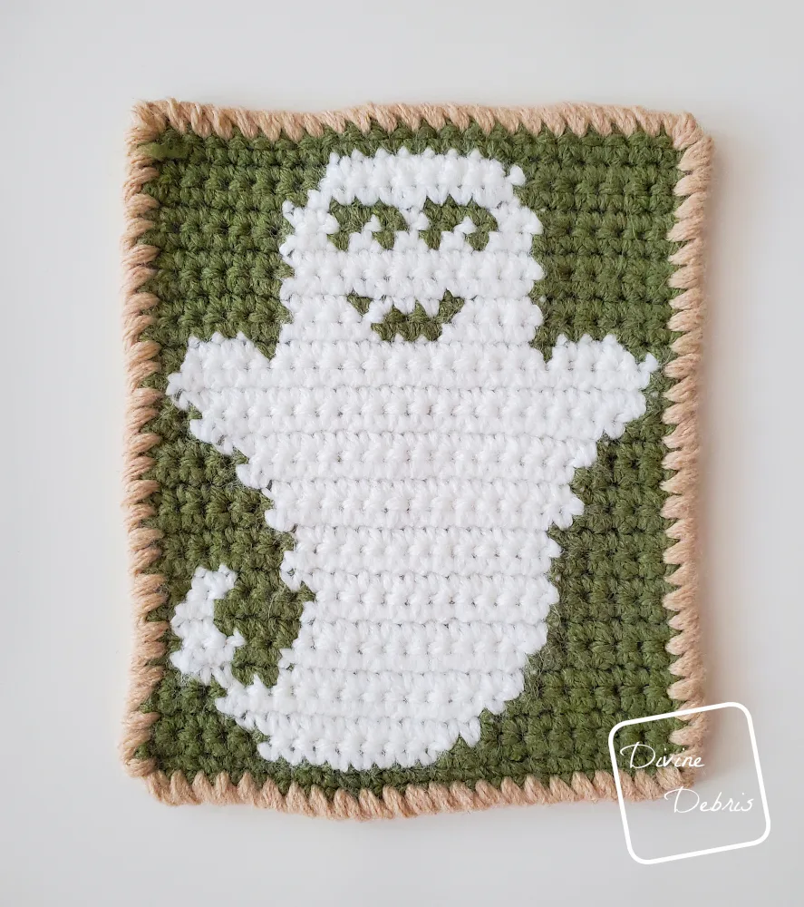 [Image description] Top down look of the right side of the green and white Cute Ghost Coaster crochet pattern.