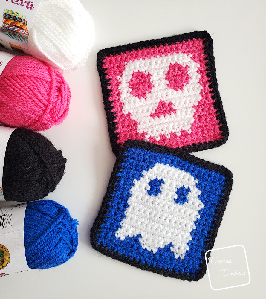 [Image description] Top down view of the Skull and Ghost Halloween Squares with skeins of yarn along the left side of the photo on a white background.