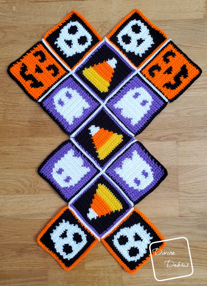 [Image description] Patchwork Halloween Bag assembly photo 1 - all 13 squares are seamed and are laying on an wooden background