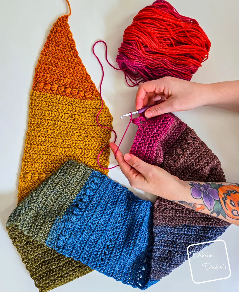 [Image description] Top down look of an unfinished Loretta Scarf made with Mandala being worked on by a pair of white woman's hands. 