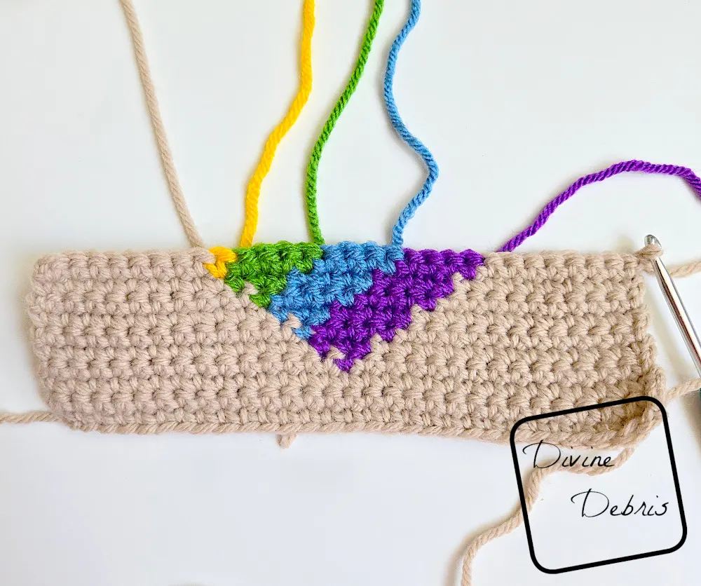 [Image description) a half done Rainbow Heart Coaster on a white background showing the individuals strands of color from the RS.