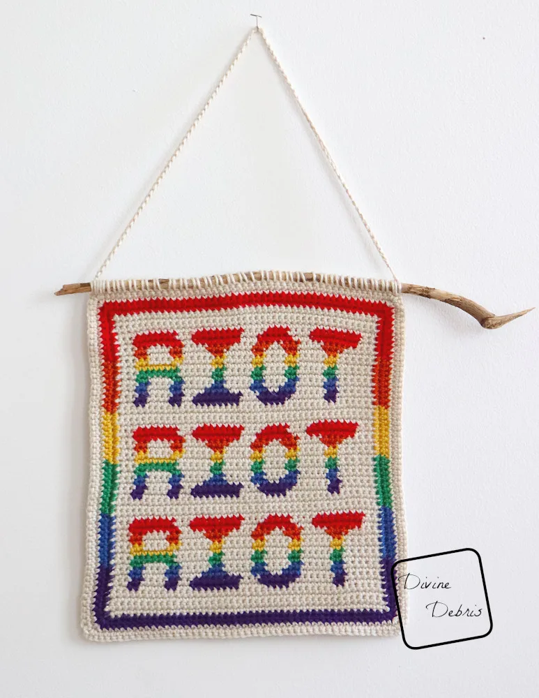 [Image description] The Riot Wall Hanging hangs off a pin on a white background.