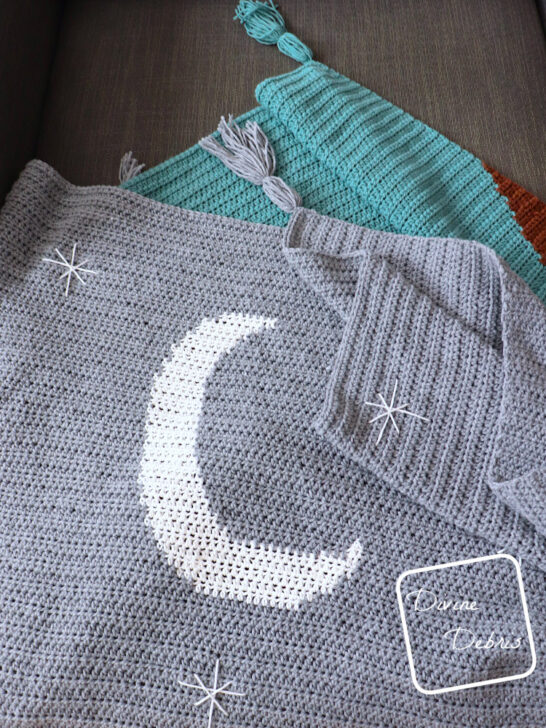 [Image description] Close up view of the Moon, stars, and tassels on the Moon Rise Mountains Blanket.