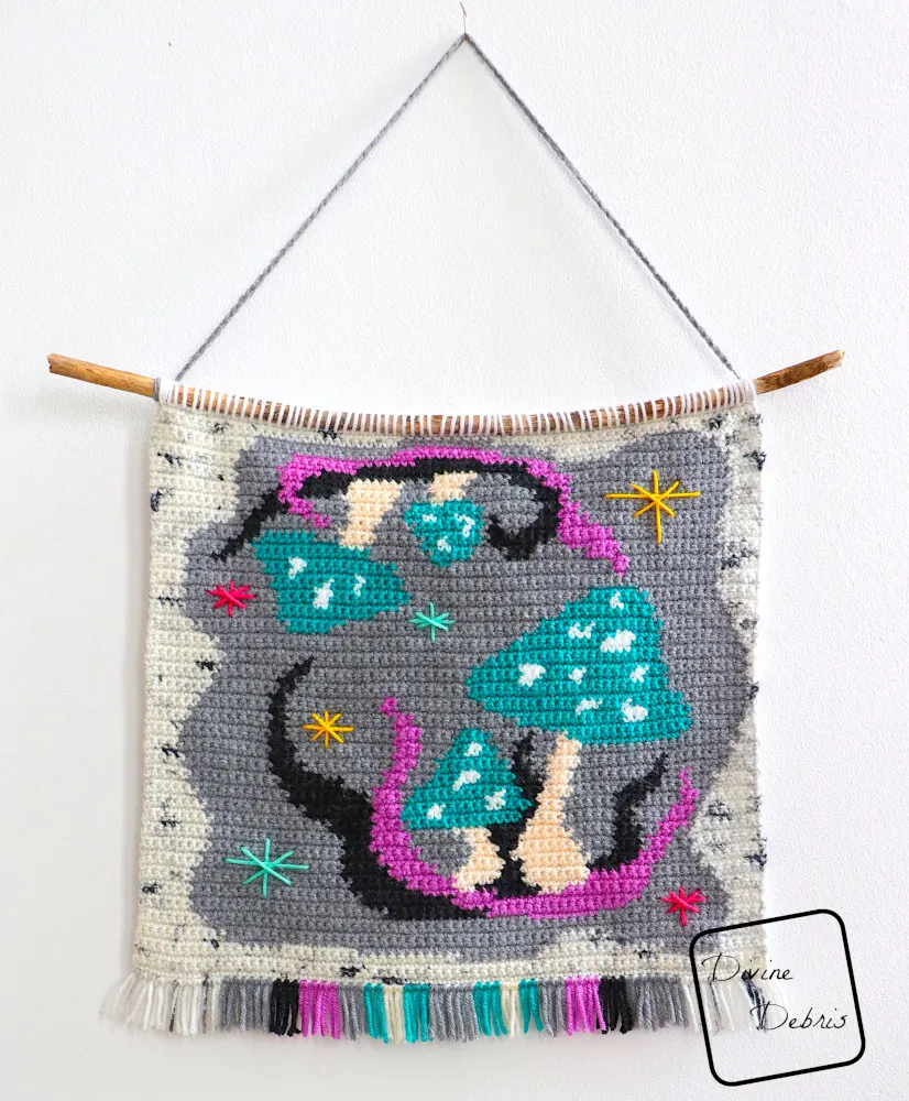 [Image description] The Wild Mushrooms Wall Hanging hangs gently on a white wall.