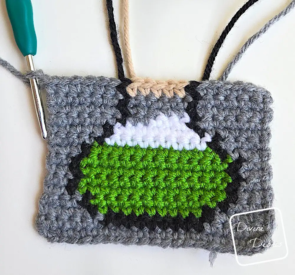 [Image description] Top down look at an unfinished right side Cute Potions Coaster on a white background and strings coming from the top of the design.